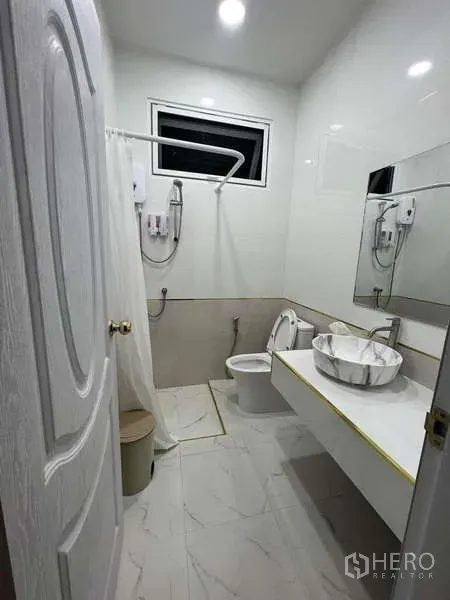Detached House for rent in Lat Krabang, Bangkok - Modern bathroom with walk‑in shower, marble‑look tiles, large mirror and vessel sink.
