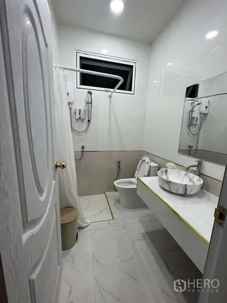 Detached House for rent in Lat Krabang, Bangkok - Modern bathroom with walk‑in shower, marble‑look tiles, large mirror and vessel sink.