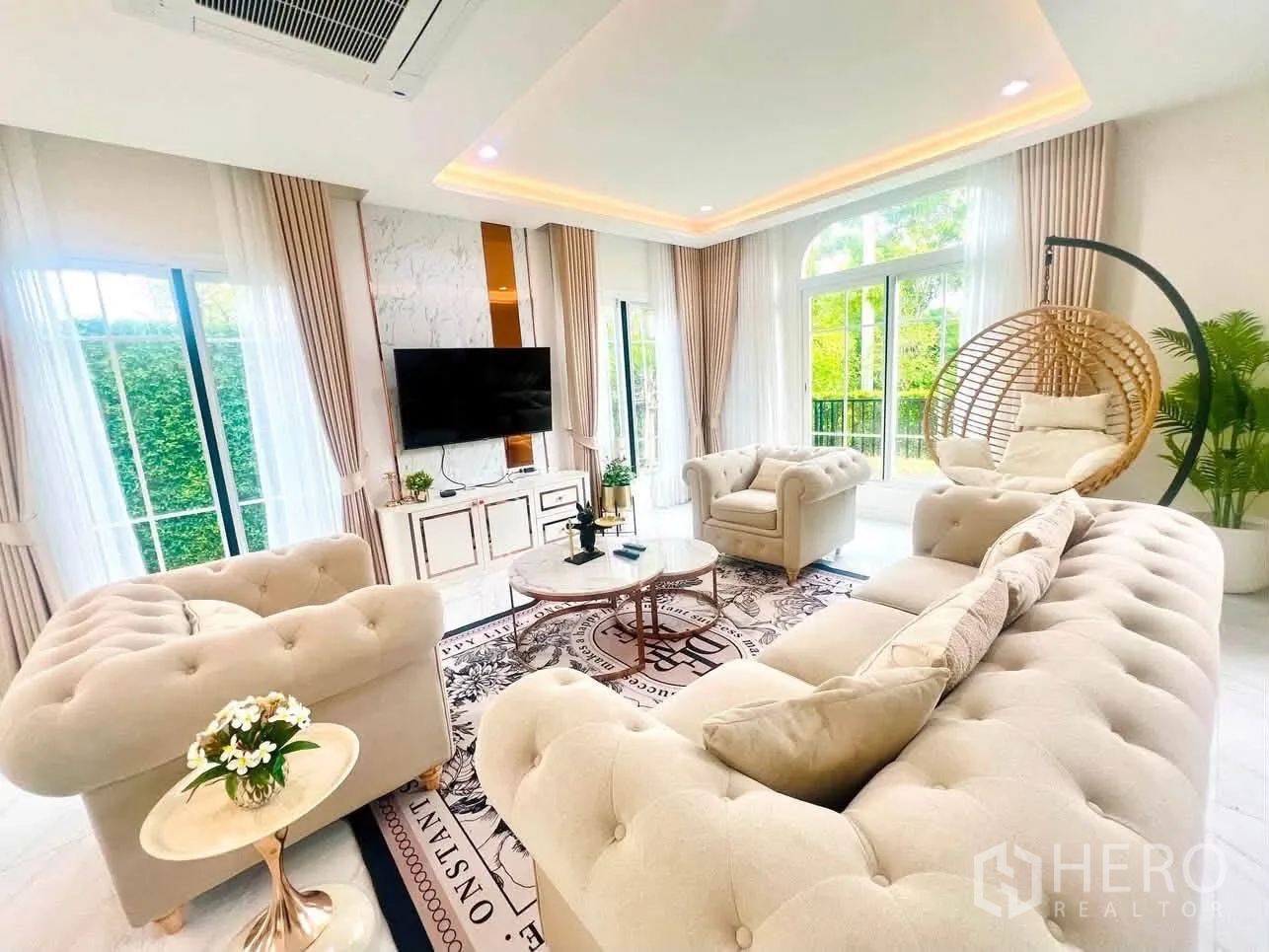 บ้านเดี่ยว for rent in Bang Phli, Samut Prakan - ห้องนั่งเล่นหรู โซฟาทรงเชสเตอร์ฟิลด์ ผนังทีวี หน้าต่างบานใหญ่ และชิงช้าแขวน