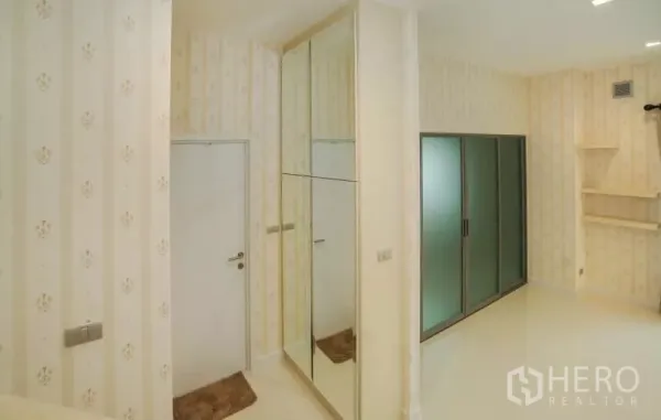 独立式住宅 出售在Lat Krabang, Bangkok - 室内走廊，带镜面衣柜与磨砂推拉门。