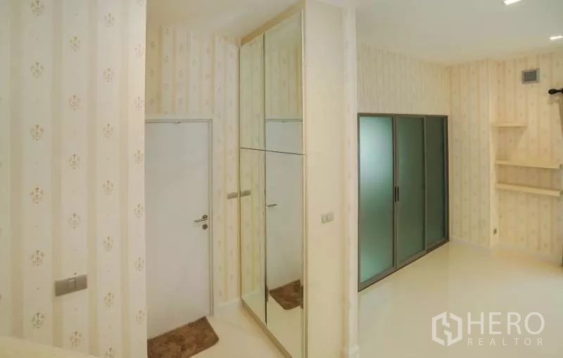 独立式住宅 出售在Lat Krabang, Bangkok - 室内走廊，带镜面衣柜与磨砂推拉门。