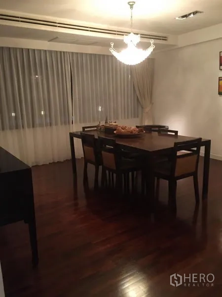 公寓 出租 - 餐区设六人木餐桌与吊灯，搭配纱帘。
