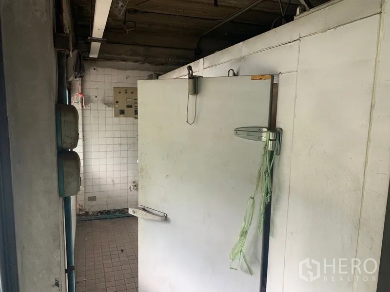 Shophouse for rent in Watthana, Bangkok - Walk-in cold room door in a tiled service area.