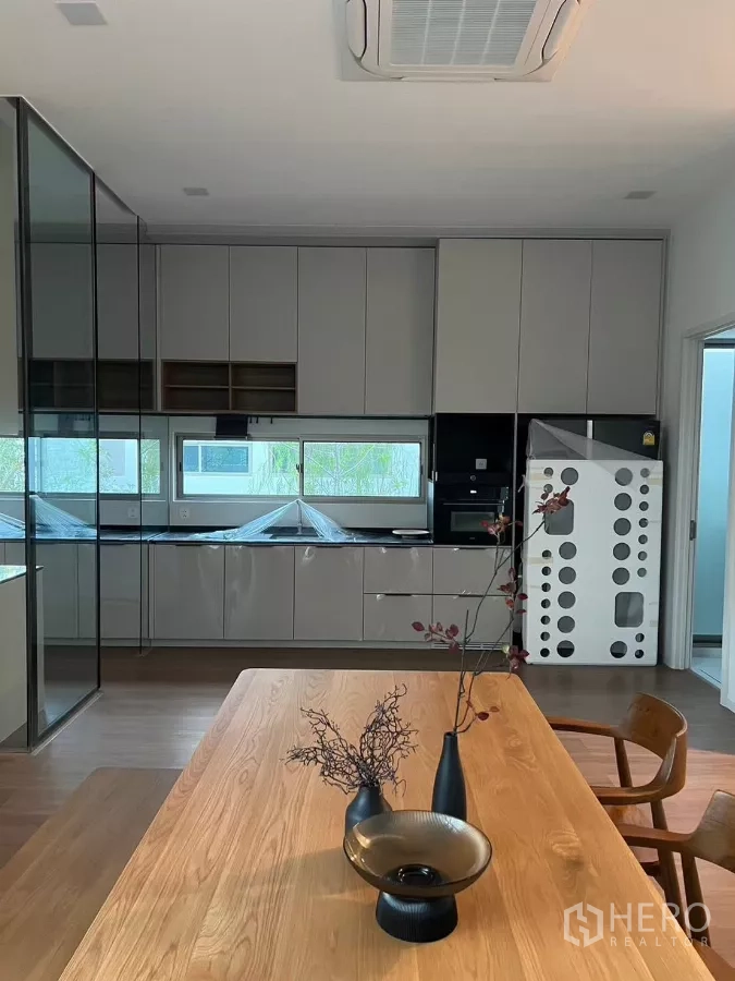 Detached House for rent in Saphan Sung, Bangkok - Modern kitchen with full-height cabinetry, window strip and built-in appliances.