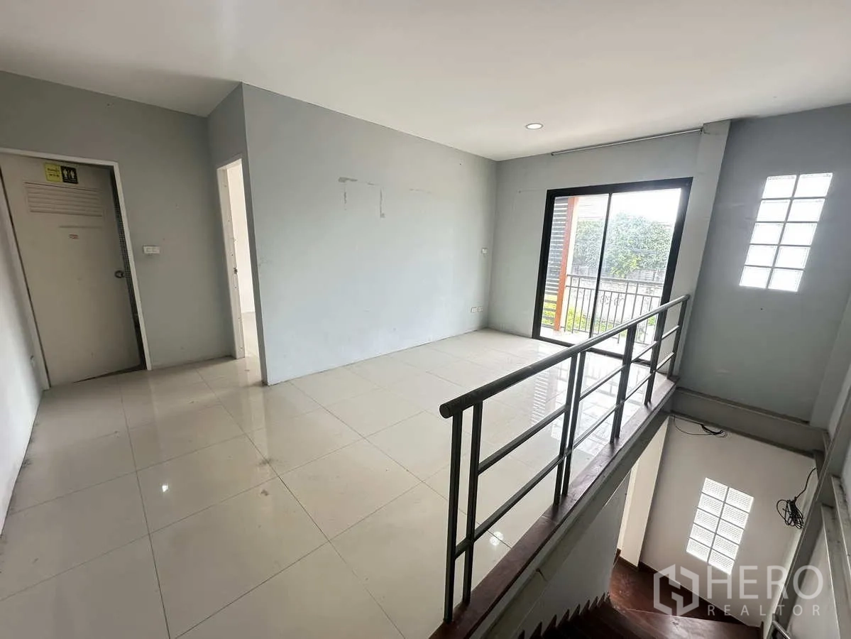 Warehouse for rent or sale in Bang Yai, Nonthaburi - Stair landing with metal railing and sliding glass door opening to a small balcony.