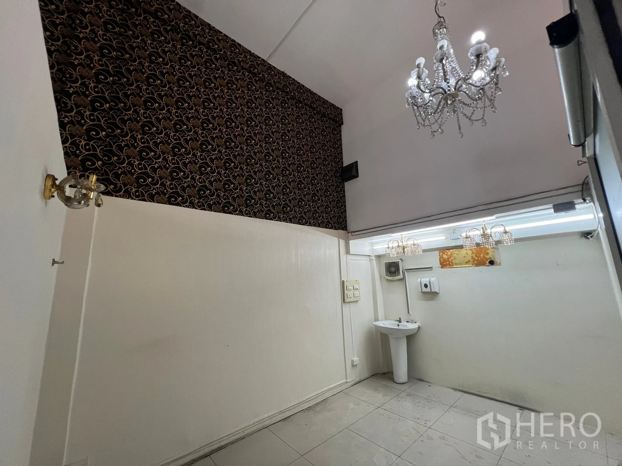 Shophouse for rent in Khlong Toei, Bangkok - Small white room with a pedestal sink and crystal chandelier.