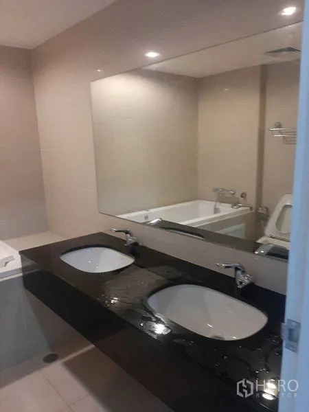คอนโด ให้เช่าหรือขายในHuai Khwang, Bangkok - ห้องน้ำเคาน์เตอร์หินดำ อ่างล้างหน้าคู่ กระจกบานใหญ่ และอ่างอาบน้ำ
