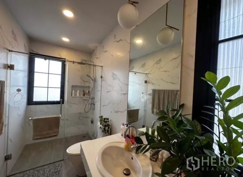 Townhouse for rent in Yan Nawa, Bangkok - Modern bathroom with glass shower enclosure and marble-effect tiles.