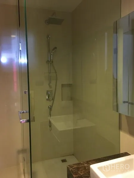Condominium for rent or sale in Watthana, Bangkok - Bathroom featuring a glass-enclosed shower with rainfall showerhead.