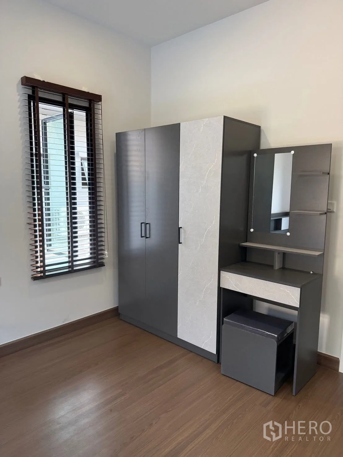 บ้านเดี่ยว for rent in Bang Phli, Samut Prakan - มุมหน้าต่างพร้อมตู้เสื้อผ้าและโต๊ะเครื่องแป้งบนพื้นไม้.