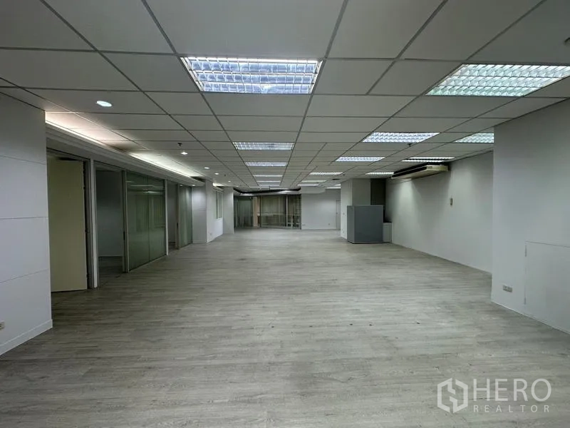 办公空间 出租在Din Daeng, Bangkok - 宽敞的办公楼层视角，侧边玻璃办公室与荧光照明。