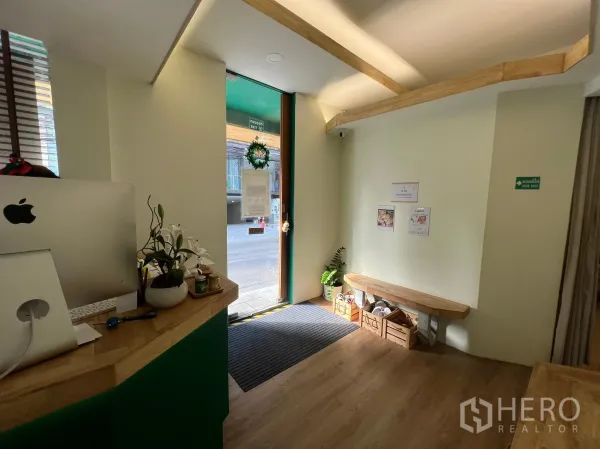 Retail Space for rent in Khlong Toei, Bangkok - Bright reception area with wood counter, bench seating and a glass door to the street.