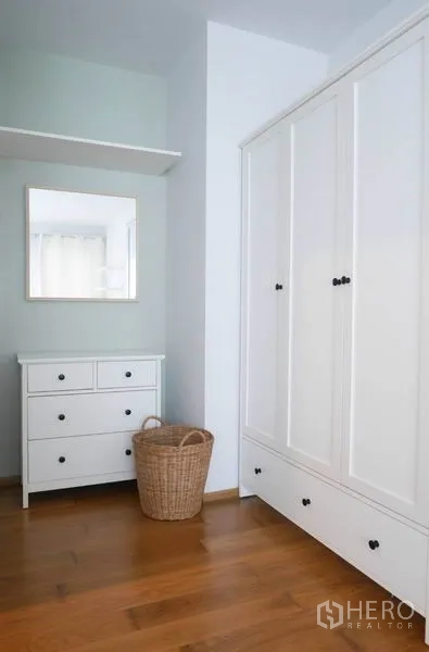Condominium for rent in Phaya Thai, Bangkok - White wardrobe and dresser with mirror in a bedroom storage corner.