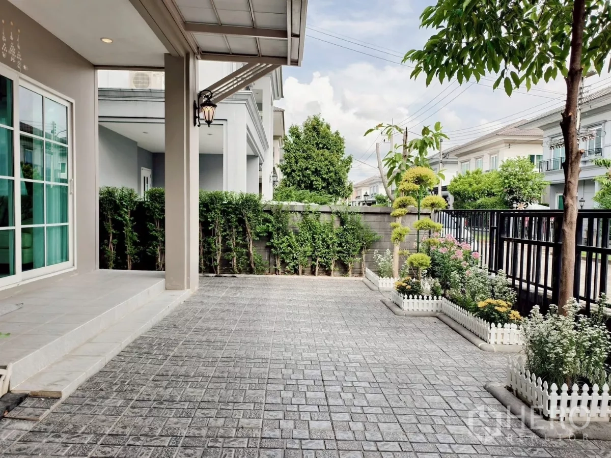 Detached House for rent in Khlong Luang, Pathum Thani - Front patio with paved yard, small garden beds and black fence