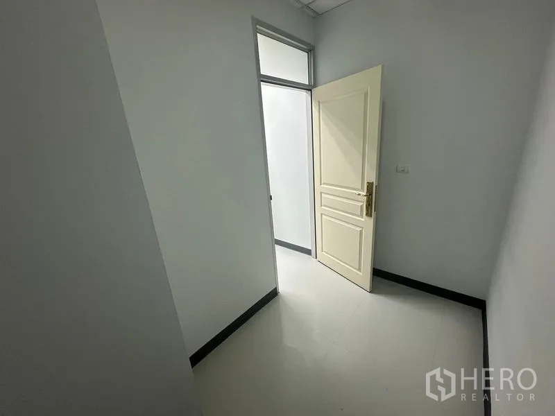 Office Space for rent in Bang Rak, Bangkok - Narrow corridor or storage nook with an open door and high transom window.