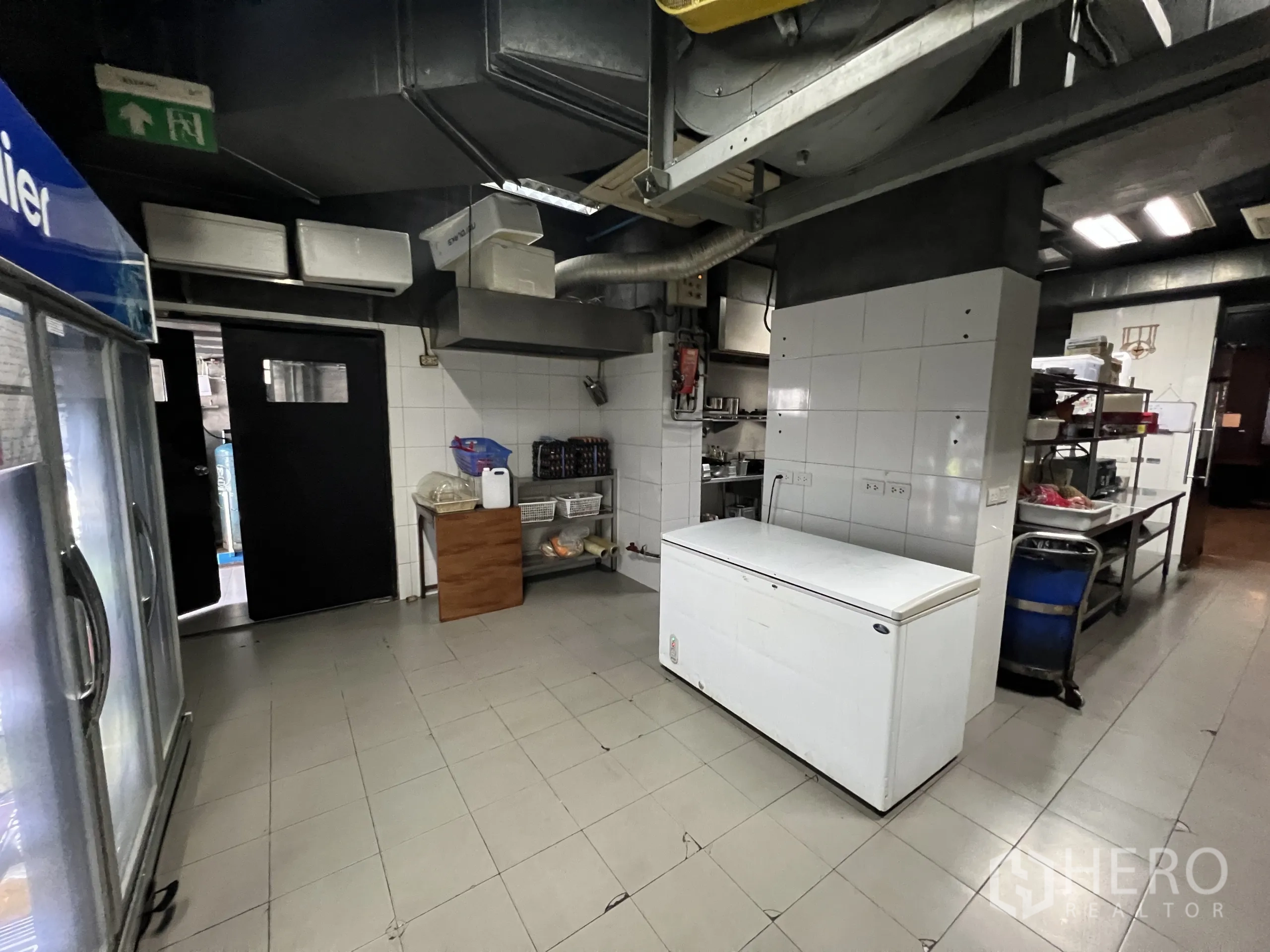 Retail Space for rent in Watthana, Bangkok - Kitchen storage zone with chest freezer, shelving, and double swing doors.