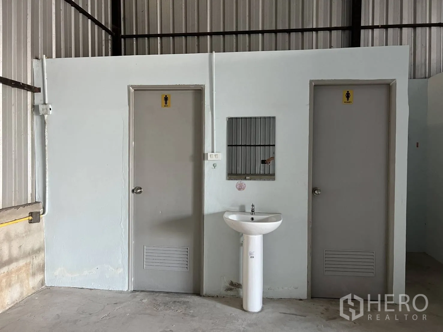 Warehouse for rent in Lat Krabang, Bangkok - Pair of restrooms with a pedestal sink inside the warehouse service area.