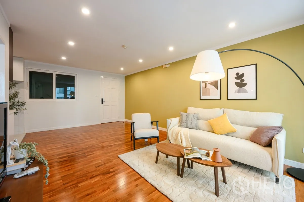 公寓 for sale in Watthana, Bangkok - 宽敞客厅，嵌灯照明、绿色特色墙、地毯与实木地板。