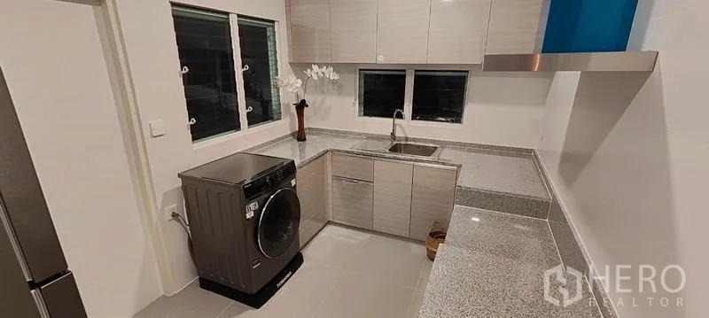 Detached House for rent in Prawet, Bangkok - Utility kitchen and laundry room with washer, sink, and ample counter space.
