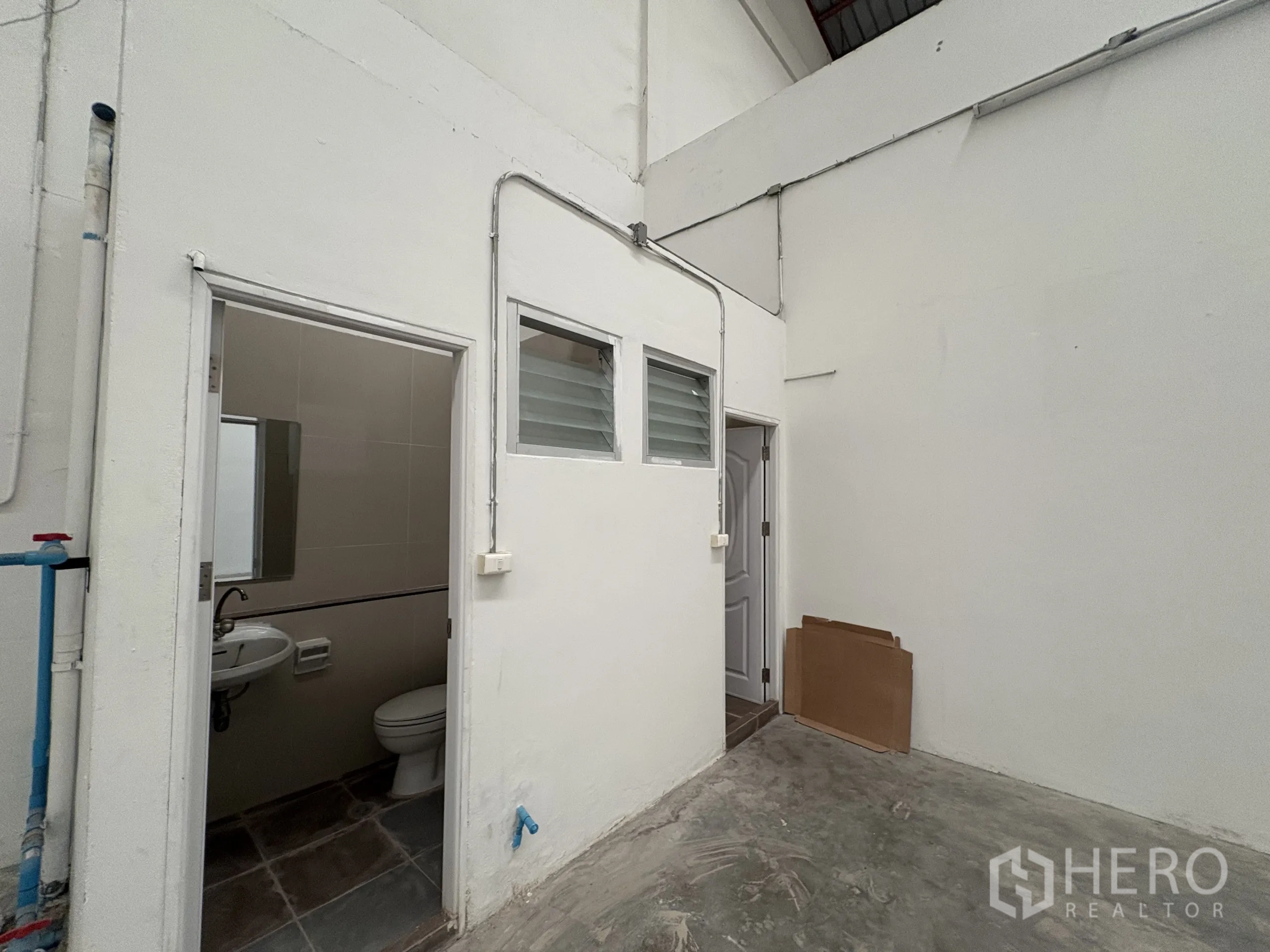 Factory for rent in Phra Samut Chedi, Samut Prakan - Utility core with office and service doors plus restrooms inside the factory.