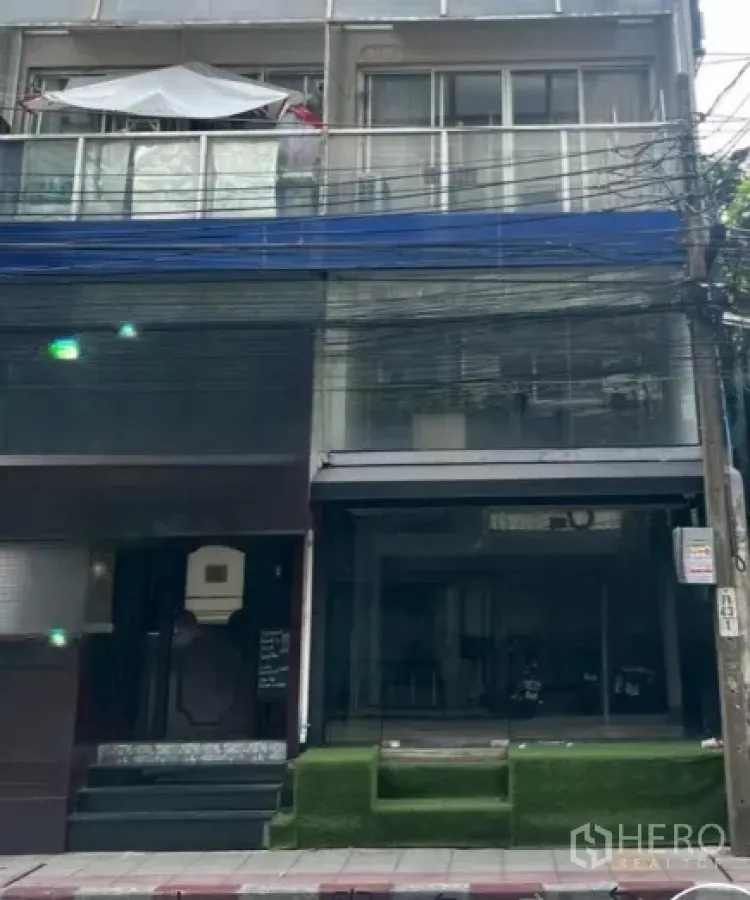 Retail Space for rent in Watthana, Bangkok - Street-facing shophouse exterior with glass storefront and raised turf steps in Bangkok.
