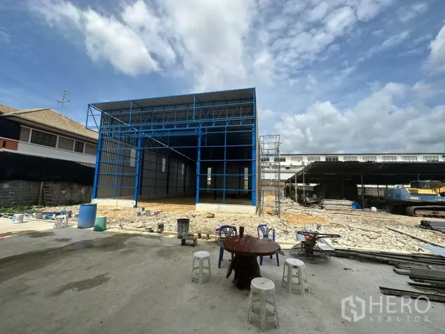คลังสินค้า ให้เช่าในWang Thonglang, Bangkok - ด้านหน้าโกดังโครงเหล็ก พร้อมลานกว้างสำหรับขนถ่ายสินค้าและนั่งร้านก่อสร้าง