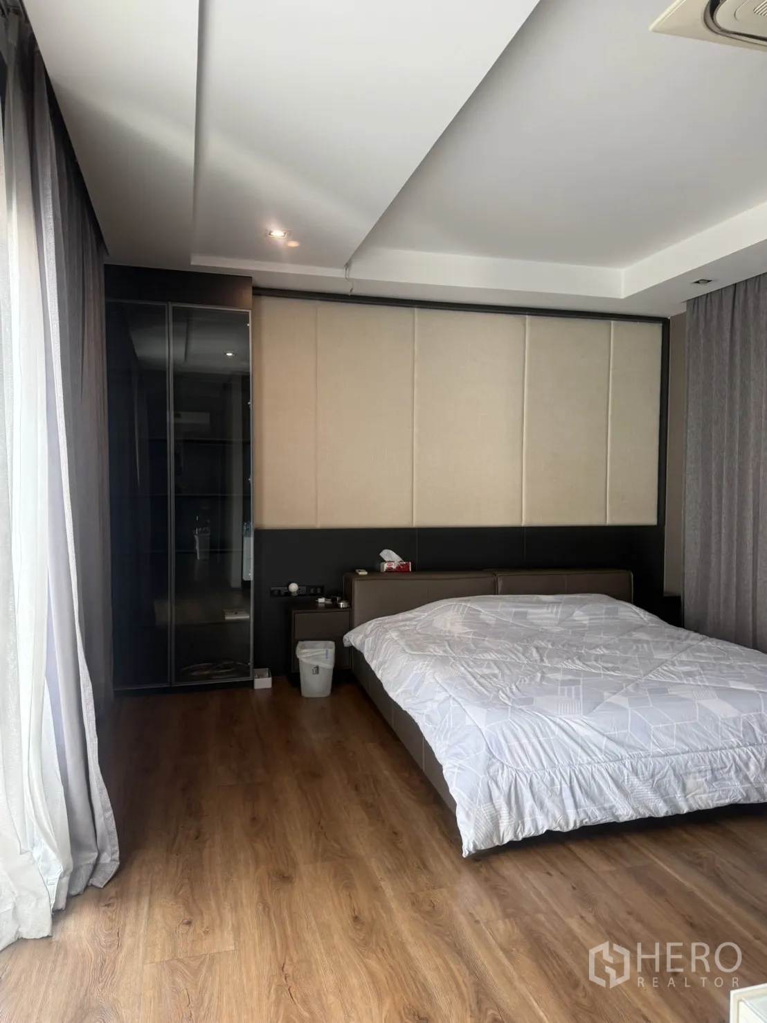 Detached House for rent in Bang Kapi, Bangkok - Spacious master bedroom with wood floors and glass-front wardrobe by balcony.