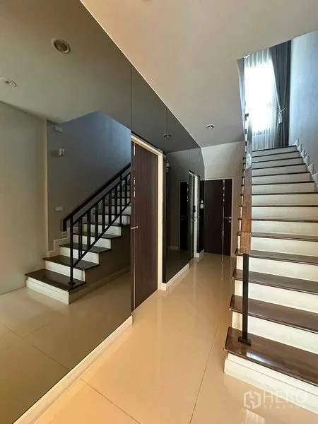 独立式住宅 出售在Prawet, Bangkok - 楼梯厅，亮面地砖、多扇门与直梯。