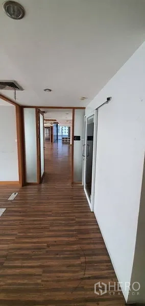 สำนักงาน ให้เช่าในWatthana, Bangkok - โถงทางเดินพื้นไม้ มีประตูเชื่อมสู่พื้นที่ทำงานสว่างพร้อมวิวสกายไลน์.