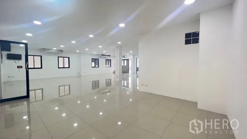 Warehouse for rent in Bang Phli, Samut Prakan - Open-plan office space with white walls, downlights and black-trimmed windows.