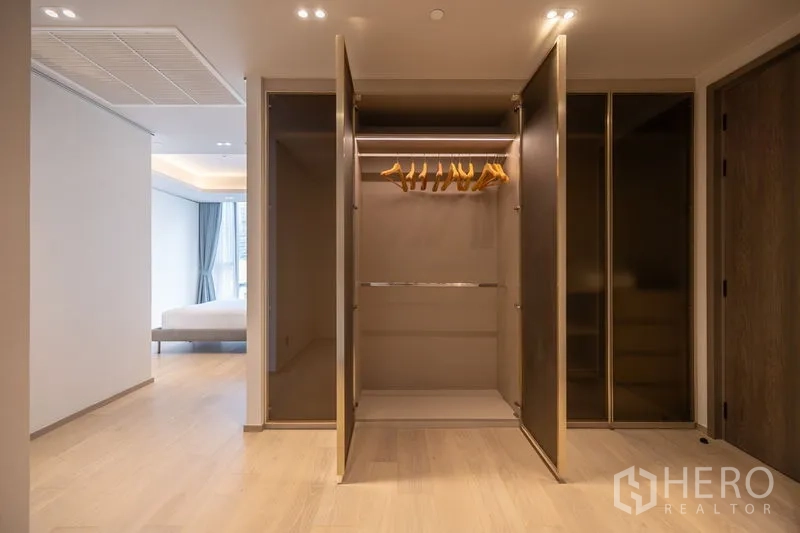 Condominium for rent in Pathum Wan, Bangkok - Open wardrobe with lighting and hangers in the dressing area.