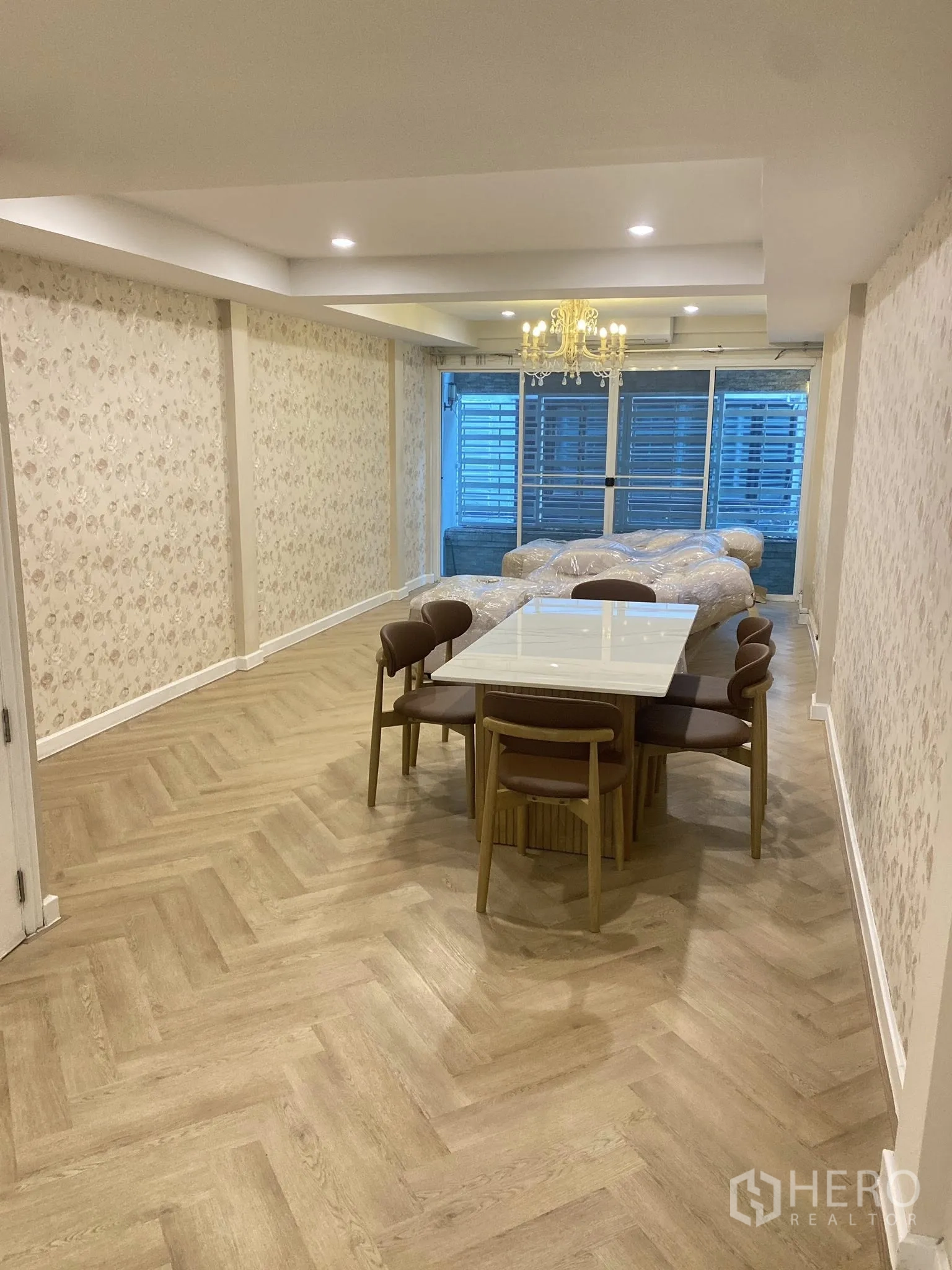 家庭办公室 for rent in Pathum Wan, Bangkok - 餐区配大理石餐桌、吊灯以及带格栅的推拉门立面。