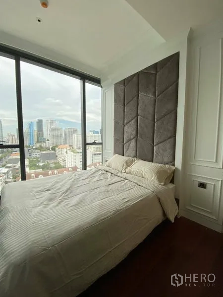 公寓 出租在Watthana, Bangkok - 主卧配高靠背软包床头，落地窗享全景城市景观。