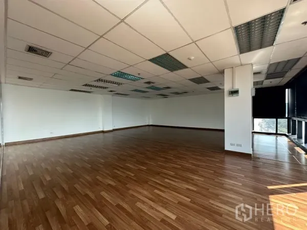 办公空间 出租在Watthana, Bangkok - 宽敞未配家具的办公区，木地板与网格天花照明。