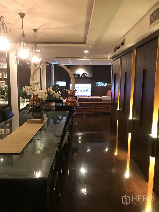 公寓 出售在Yan Nawa, Bangkok - 长玻璃餐桌与枝形吊灯、氛围灯的优雅餐区。
