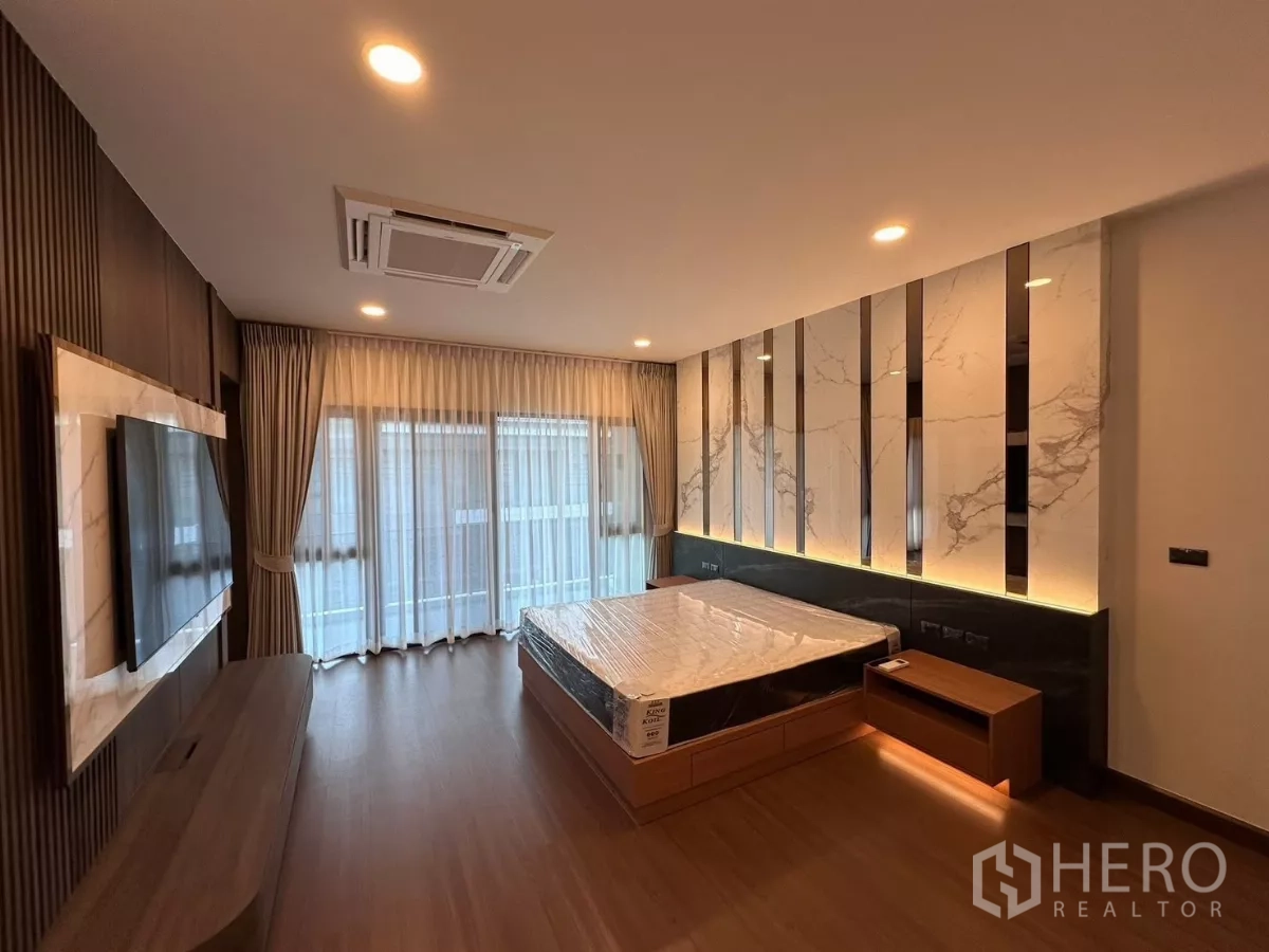 独立式住宅 出租在Bang Phli, Samut Prakan - 主卧，特色床头墙、电视面板与落地窗帘。