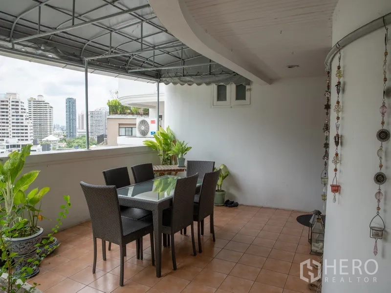 อพาร์ทเมนท์ for rent in Khlong Toei, Bangkok - มุมรับประทานอาหารกลางแจ้งใต้กันสาด พร้อมชุดโต๊ะเก้าอี้และวิวสกายไลน์.