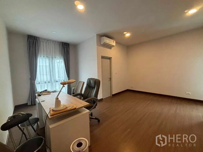 独立式住宅 出租在Mueang Nonthaburi, Nonthaburi - 大空间多功能室，带书桌、办公椅与木地板。