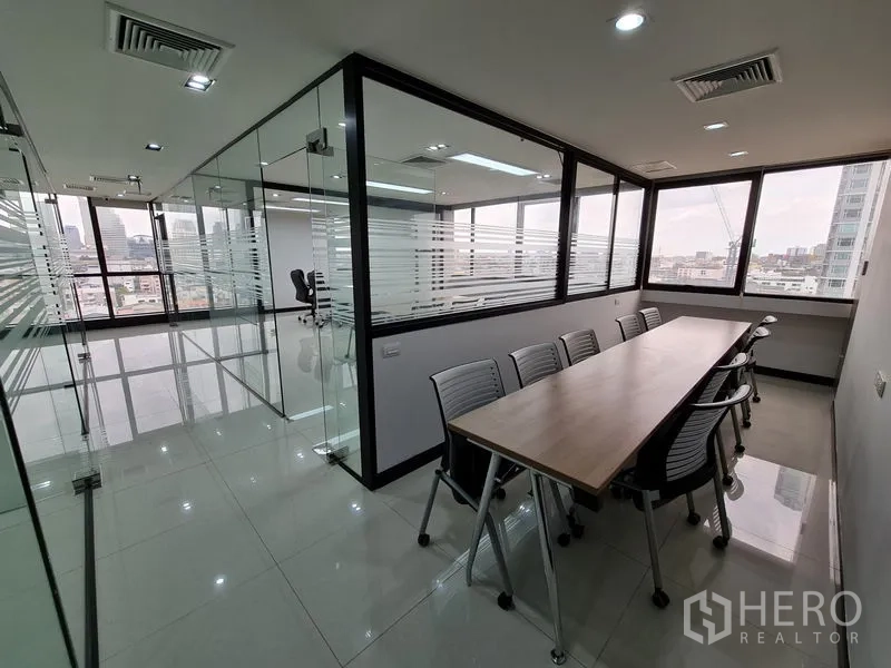 Office Space for rent in Bang Rak, Bangkok - Bright corridor of glass offices with a long meeting table and glossy tiled floors.