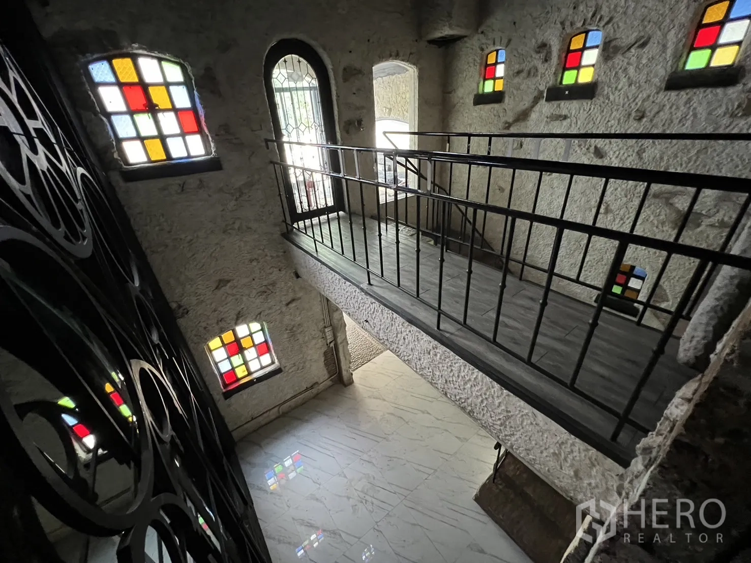 Retail Space for rent in Watthana, Bangkok - View across a mezzanine bridge above a polished white floor and colorful windows.