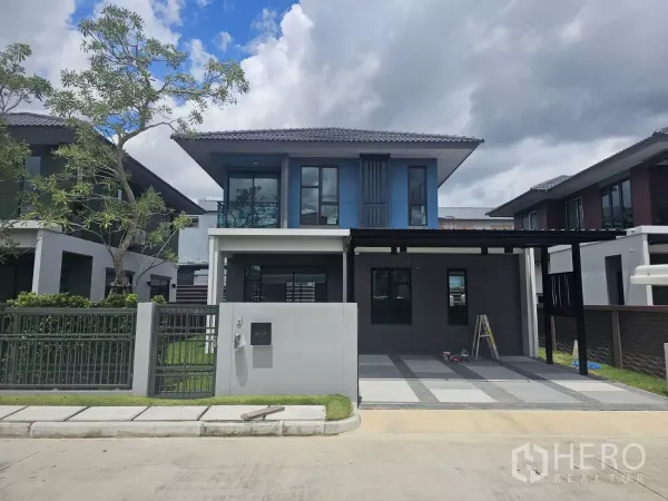 独立式住宅 出售在Lam Luk Ka, Pathum Thani - 巴吞他尼Lam Luk Ka现代两层独栋屋外观，带围栏与双车位车棚。