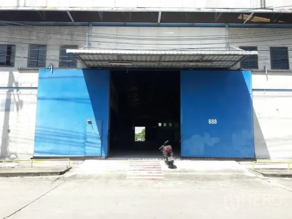货栈 出租在Mueang Samut Prakan, Samut Prakan - 仓库外立面，超大蓝色推拉门及装卸坡道，便于卡车出入
