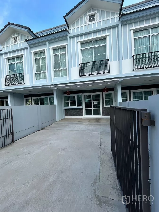 联排别墅 出租在Prawet, Bangkok - 两层联排别墅外立面，带车道与院门。