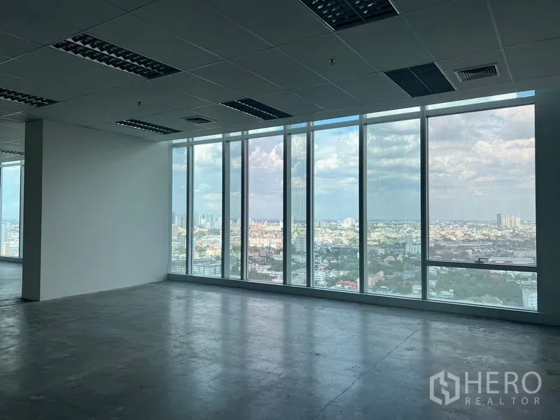 Office Space for rent - Corner workspace with full-height windows overlooking Bangkok cityscape.