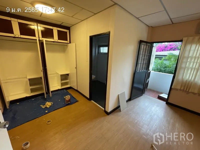 บ้าน ให้เช่าในKhlong Toei, Bangkok - ห้องนอนพร้อมตู้บิลท์อิน และประตูออกไประเบียงเล็กที่มีดอกไม้
