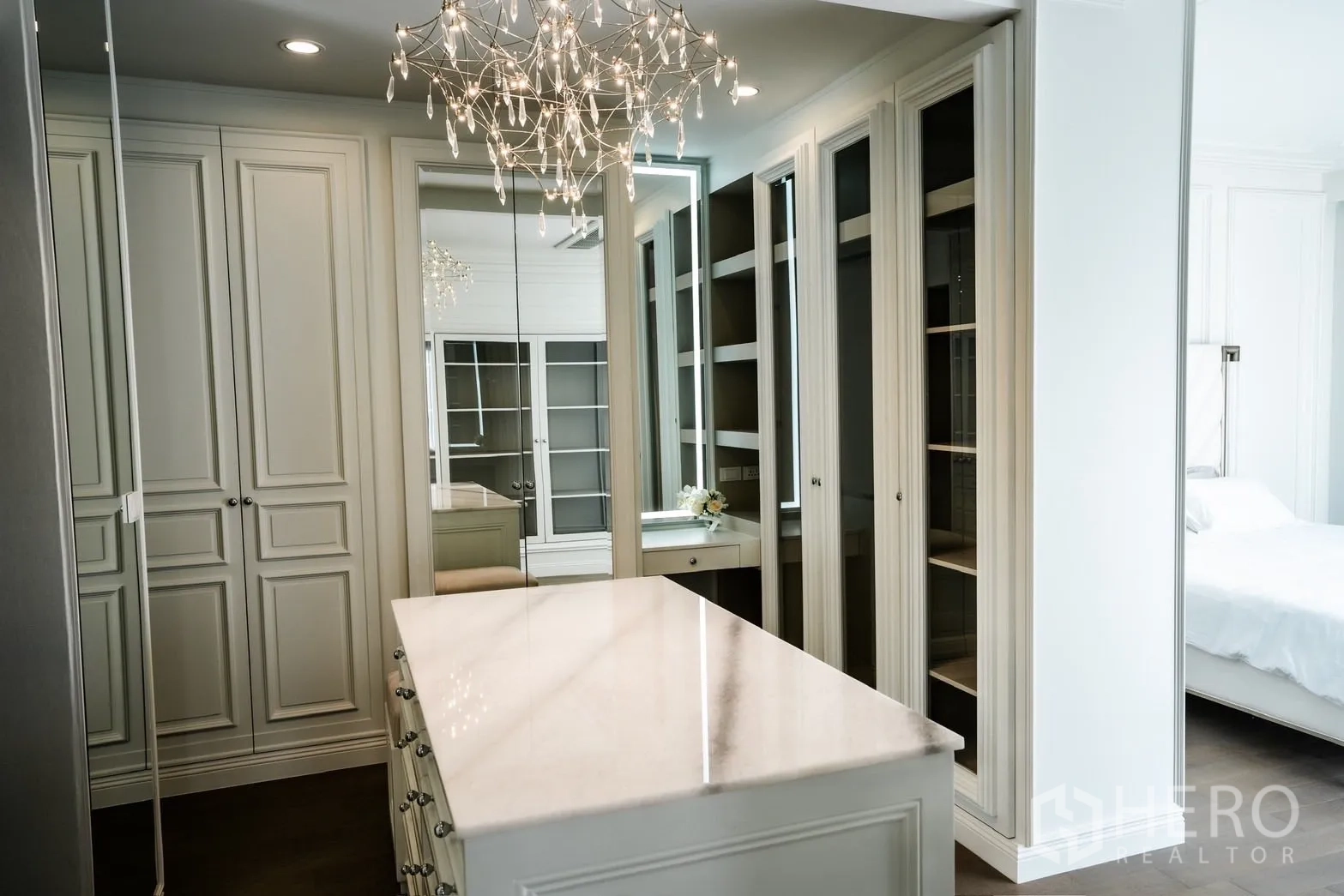 Detached House for rent or sale in Bang Kapi, Bangkok - Walk‑in closet featuring mirrored wardrobes, center island and crystal chandelier.