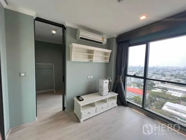 公寓 出售在Ratchathewi, Bangkok - 客厅采光充足，落地窗与城市景观，墙上置物架和电视柜