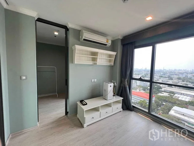 公寓 出售在Ratchathewi, Bangkok - 客厅采光充足，落地窗与城市景观，墙上置物架和电视柜