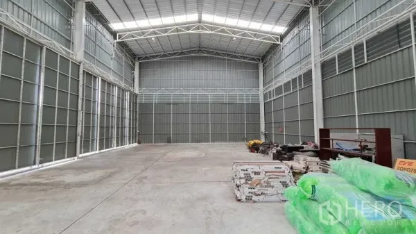 Warehouse for rent in Mueang Nonthaburi, Nonthaburi - High-ceiling warehouse interior with steel trusses, skylights and a durable concrete floor.