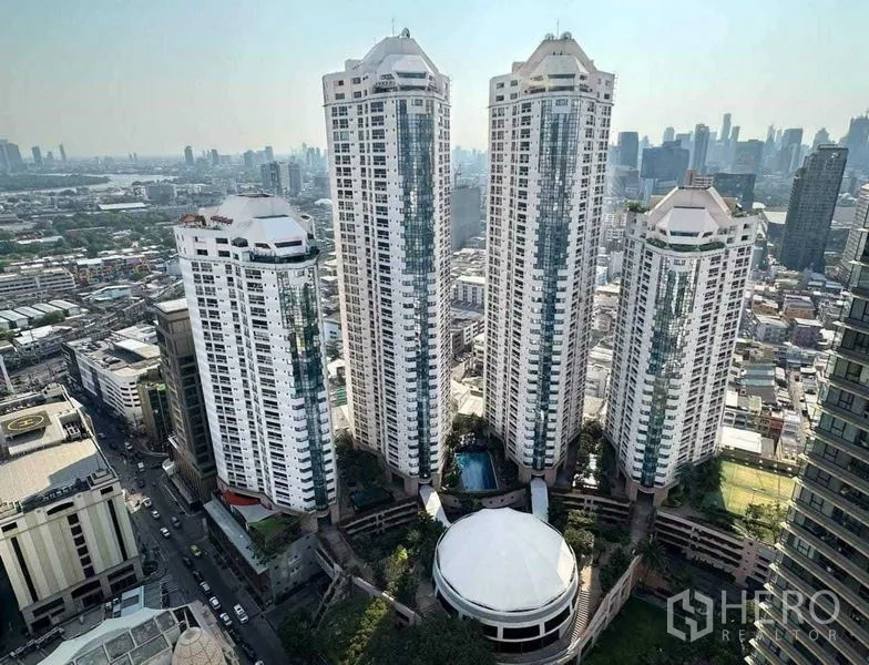 公寓 出租在Khlong Toei, Bangkok - 总统公园公寓群与曼谷天际线的航拍图